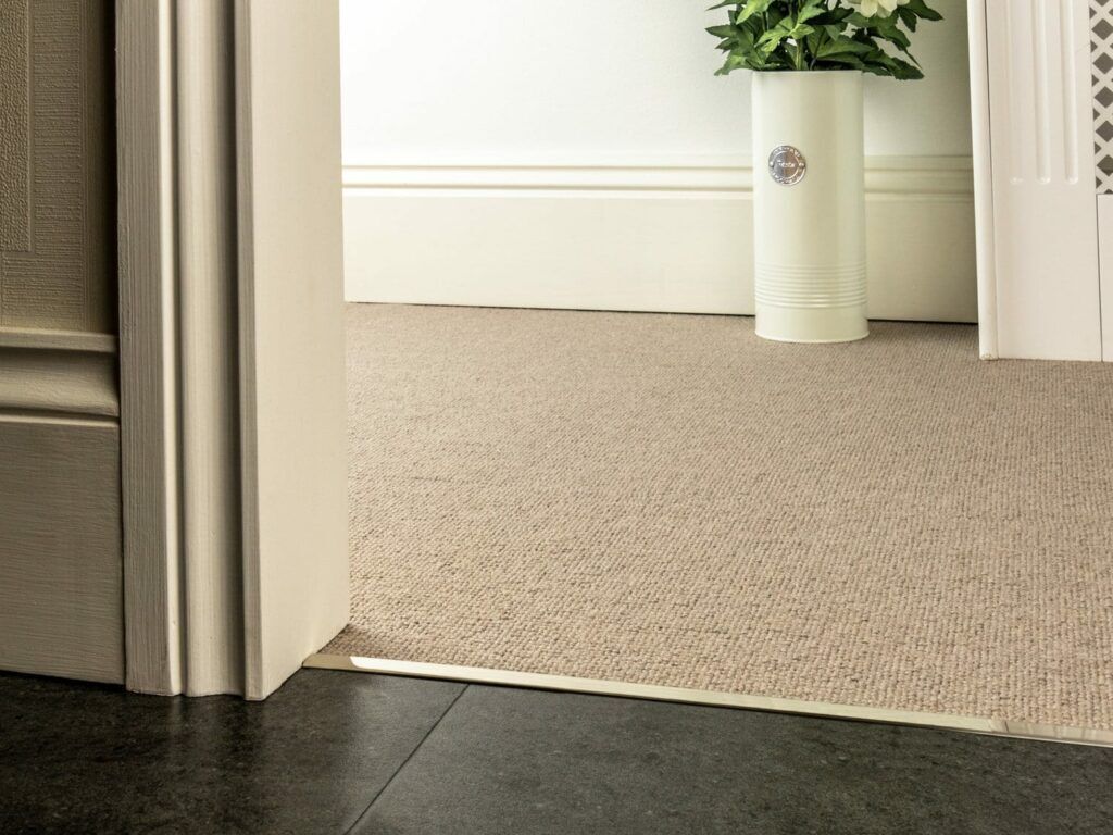 Premier Slim z bar joining a beige carpet to wood tiles, slim, polished nickel