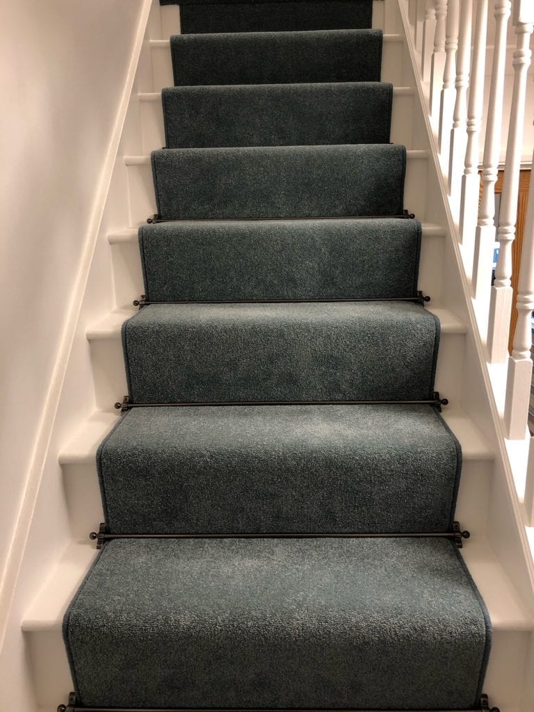 Black stair rods for carpet runners fitted on teal carpet runner