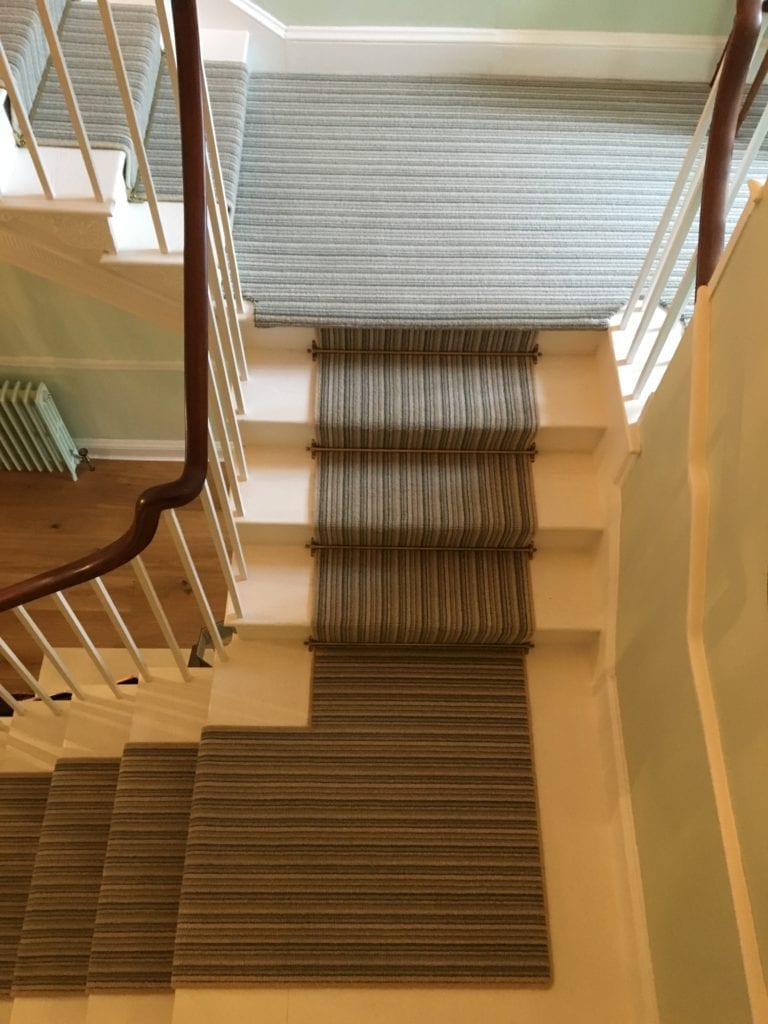 Antique brass stair rods on striped stair runner