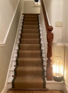 Dark wood stair rods on a sisal stair runner