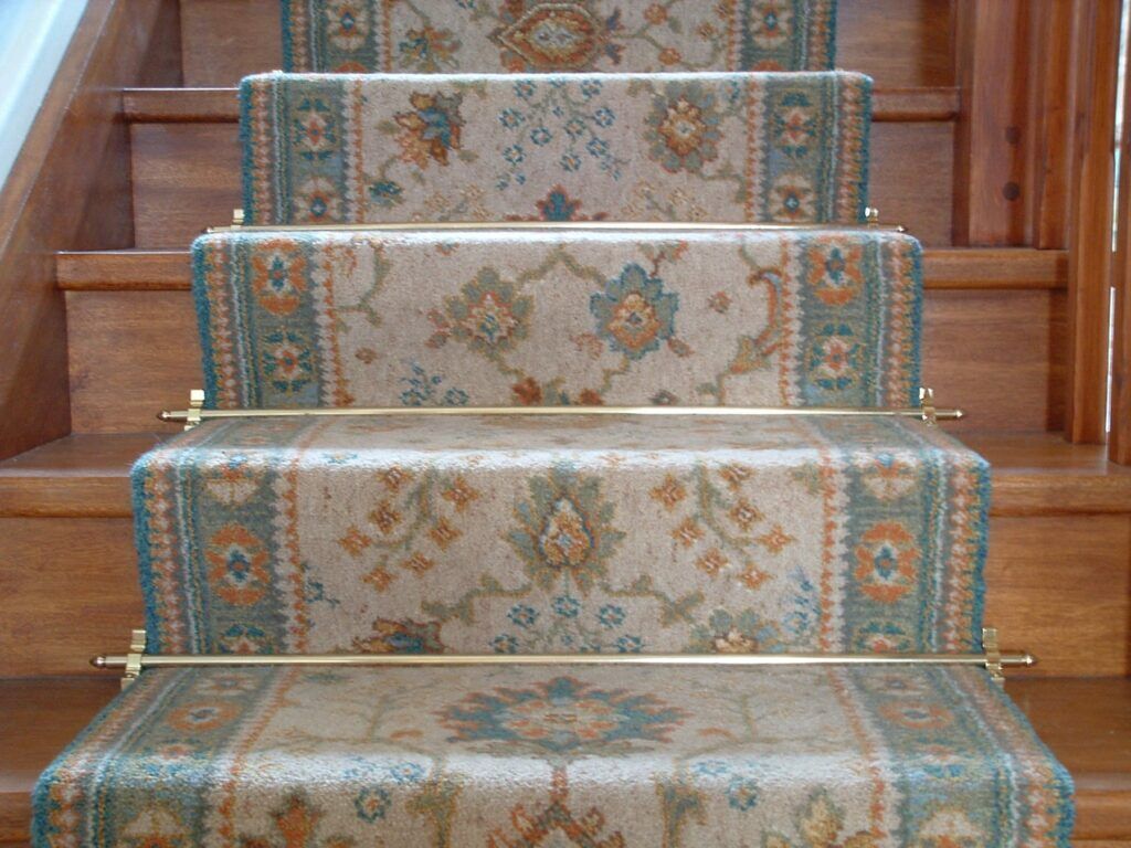 Lancaster stair rods in polished brass fitted on a patterned, blue runner