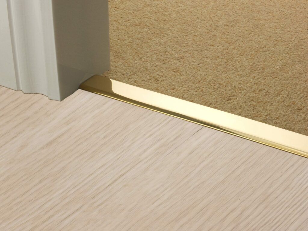 Premier Z door bar in doorway, linking carpet to tiled floor, Polished Brass