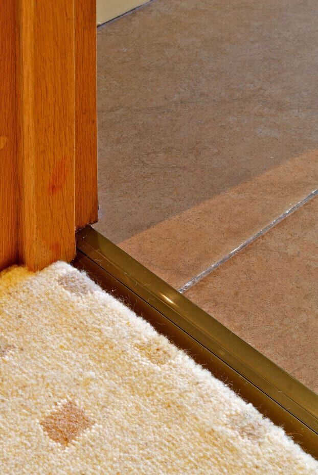 Posh door threshold carpet to tile in antique brass in doorway