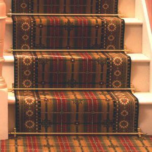 Lancaster carpet rods in polished brass fitted on tartan stair runner