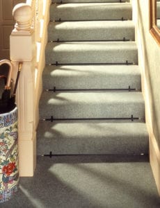 Front fix stair rods shown on a green fitted stair carpet