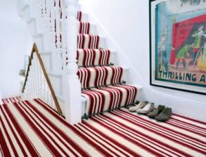 Arrow design of carpet rods for runners fitted on red & cream striped stair runner