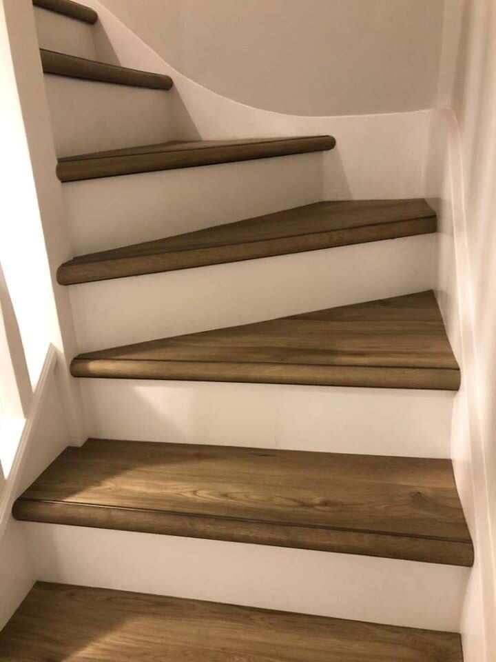 Stair nosing profile fitted to wood-look tread staircase with winder stairs