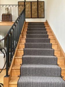 Chapel staircase featuring Balladeer antique bronze runner carpet rods