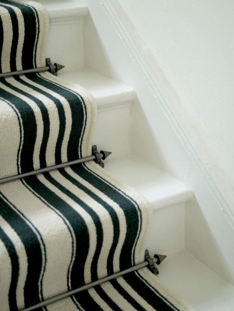 Modern stair rods - Arrow shown in black on black and white striped carpet